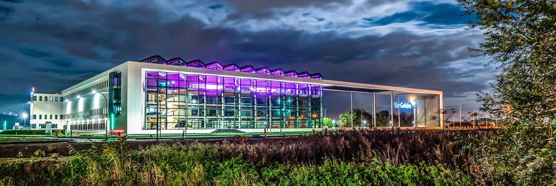 Van Gelder Experience Center bij avond, met paars-roze verlichting