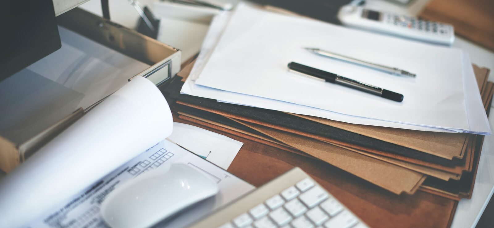 Bureau met facturen, papieren en pen