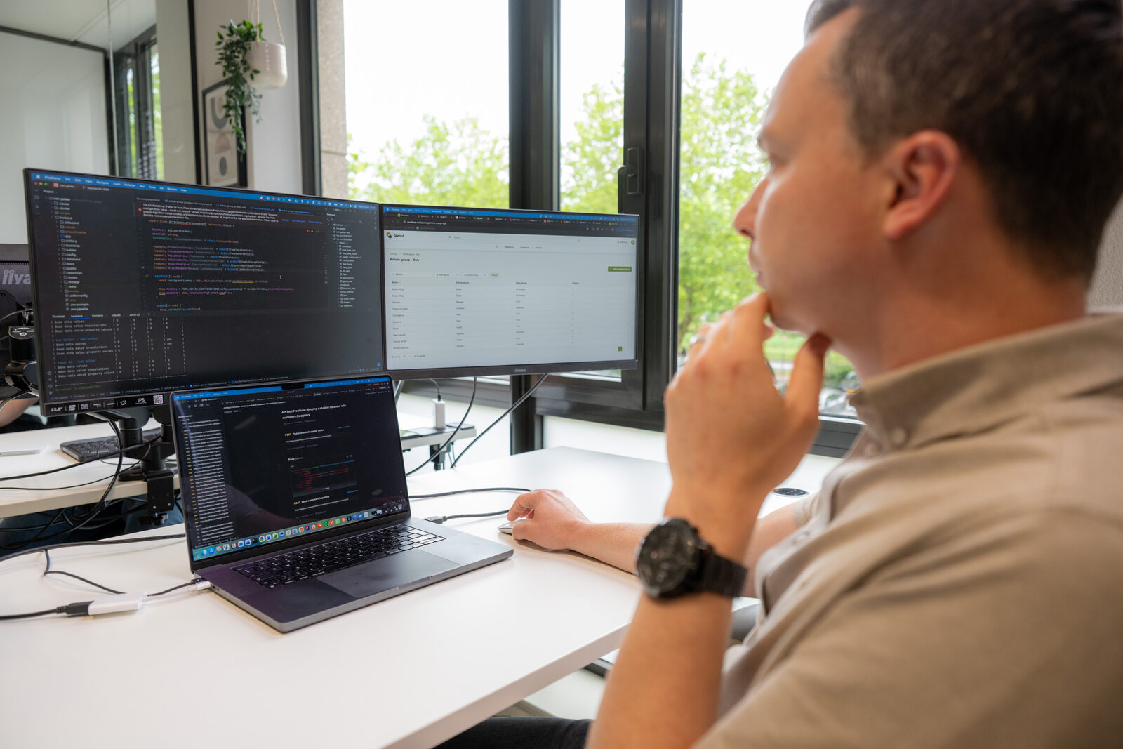 Emendis-developer aan dual-monitor werkplek met code