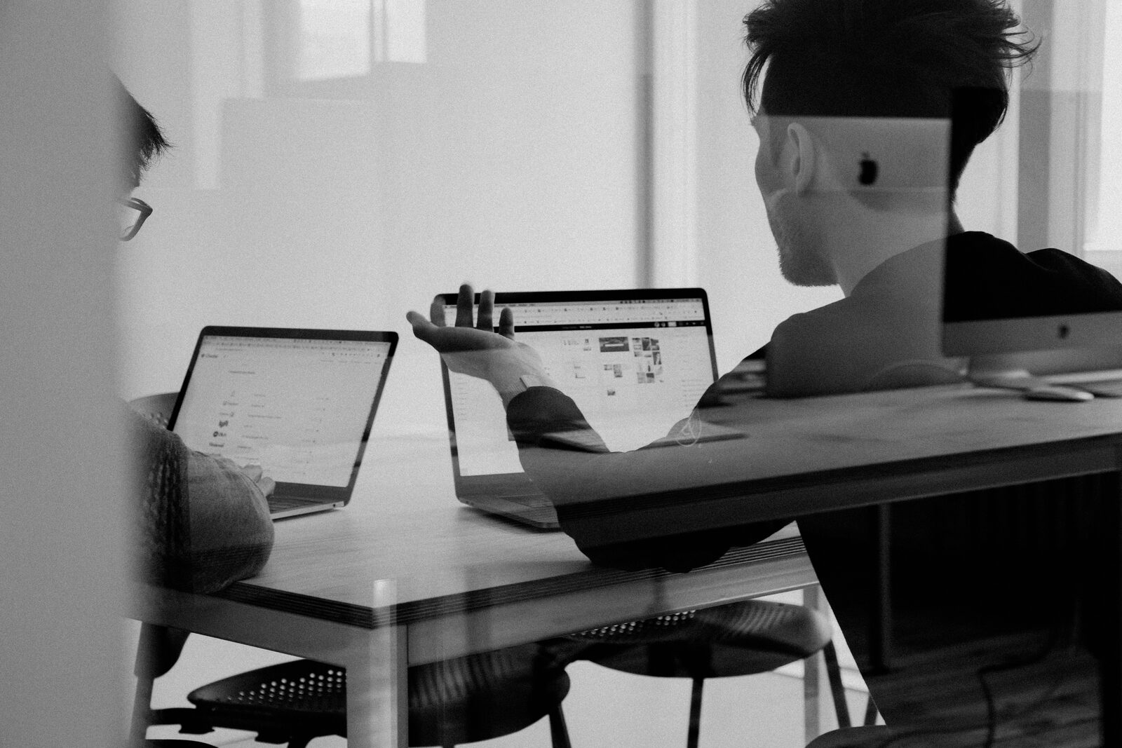 Twee teamleden in overleg met laptops