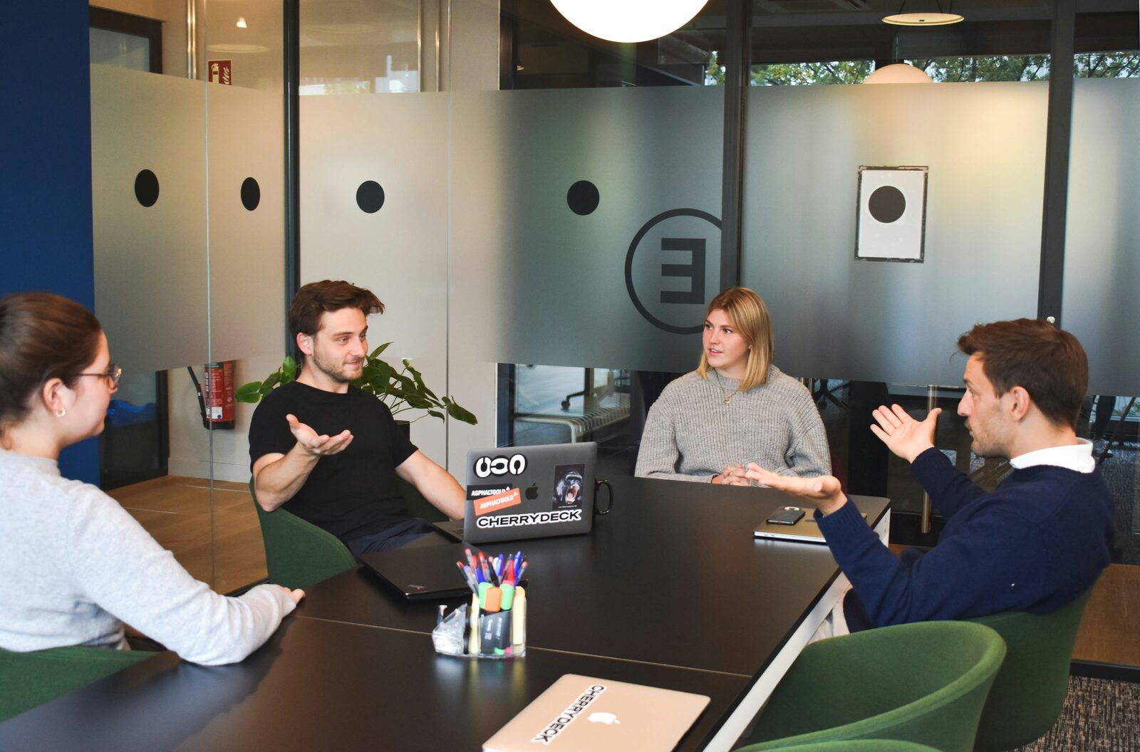 Vier collega's in overleg in moderne kantoorruimte