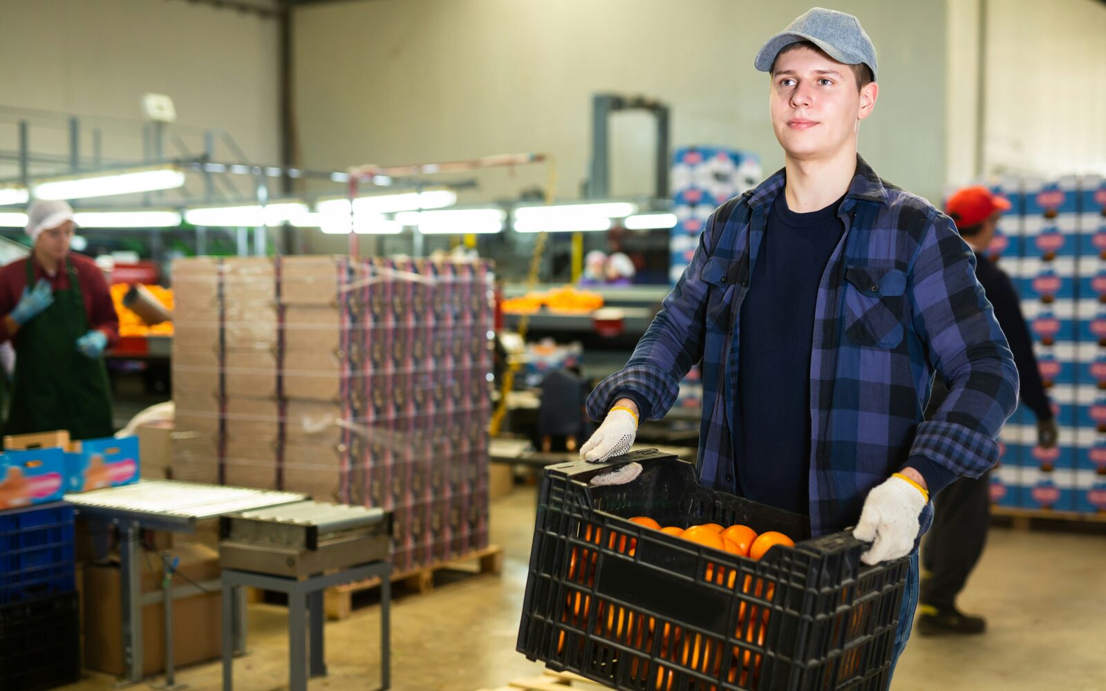 Magazijnmedewerker met krat sinaasappels
