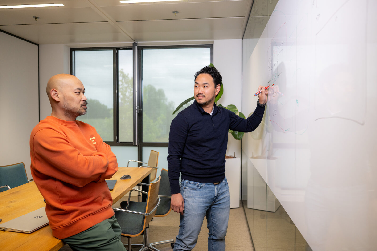 Twee Emendis-collega's overleggen aan het whiteboard