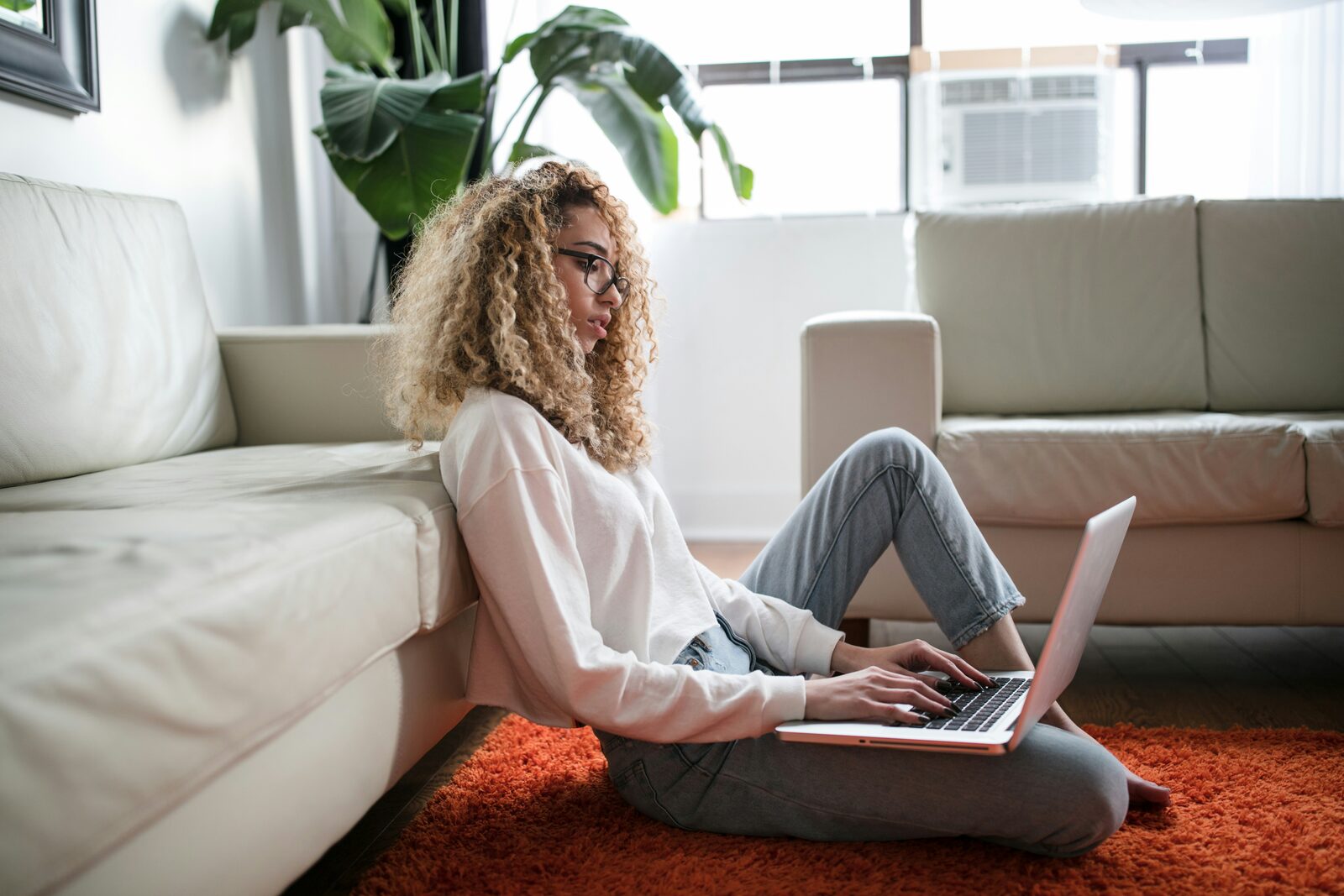 Persoon leest op laptop in een lichte ruimte